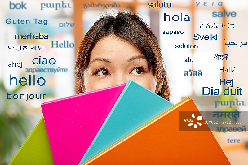 亚洲女学生藏在笔记本后面图片素材