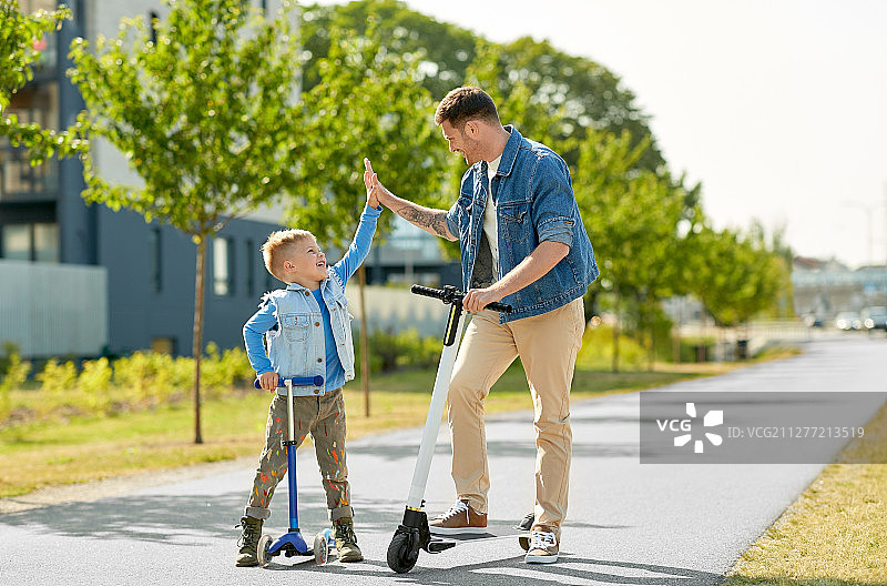 父子在城市里骑滑板车图片素材