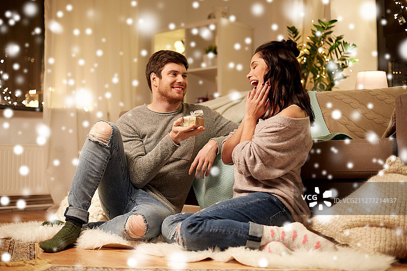 圣诞假日人物概念 - 在家手捧礼品盒的幸福情侣图片素材