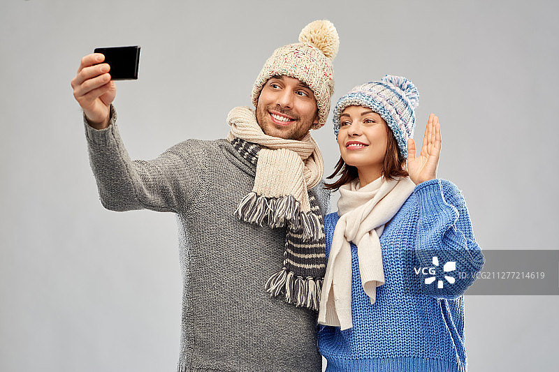 圣诞情侣在灰色背景下用手机自拍图片素材