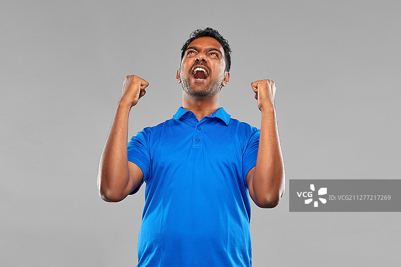 成功、情感和表达概念——庆祝胜利的快乐印度青年图片素材