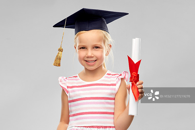 戴学士帽的快乐小女孩与文凭图片素材