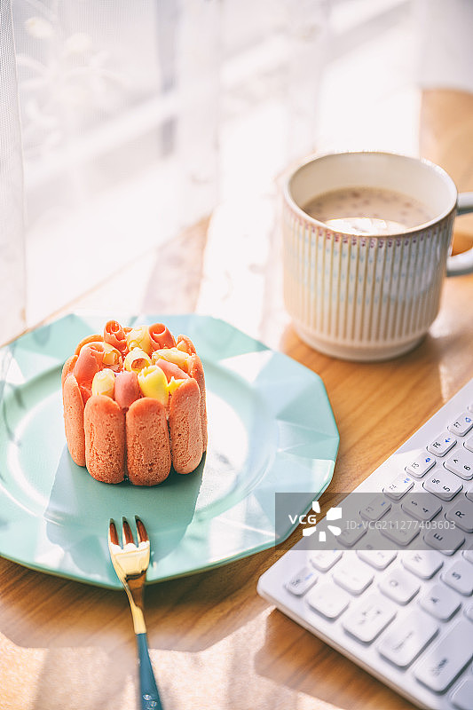 阳光明媚的天气放在办公桌上的蛋糕图片素材