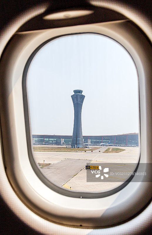飞机舷窗外的北京首都机场塔台图片素材