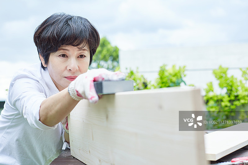 中年妇女的爱好：砂纸与木头图片素材