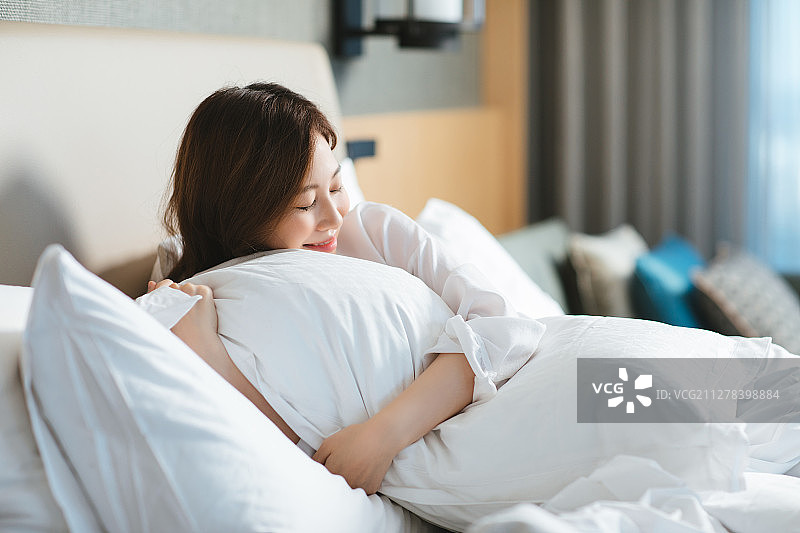 酒店卧室里微笑的女人图片素材