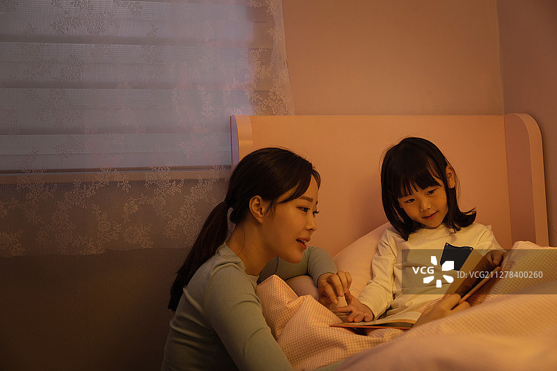 孩子、妈妈、女儿在夜晚讲故事，温馨幸福图片素材