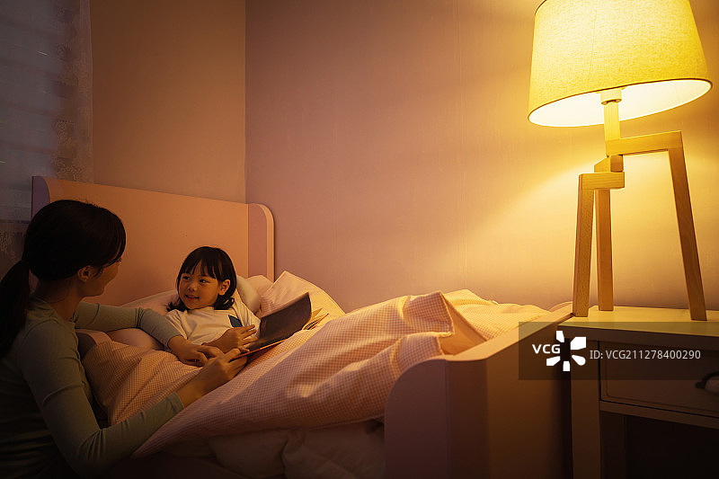 孩子、妈妈、女儿在夜晚讲故事，温馨幸福图片素材