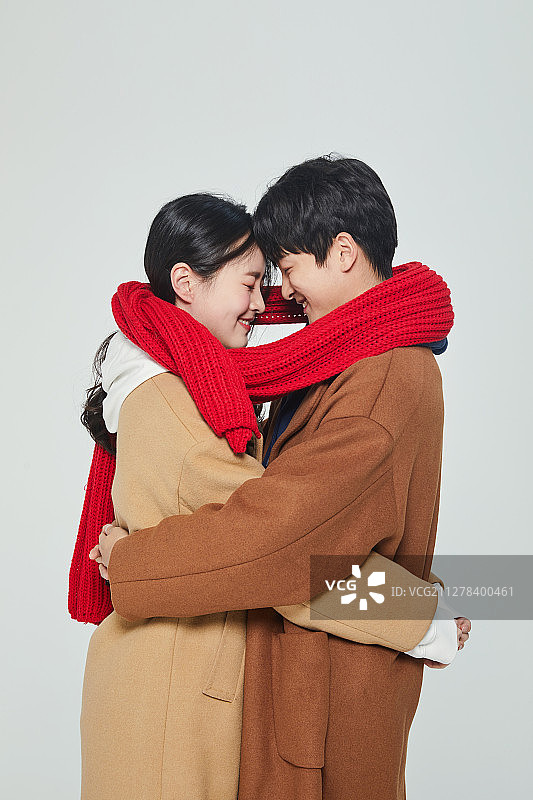 大学生情侣穿着暖和的衣服幸福地拥抱图片素材