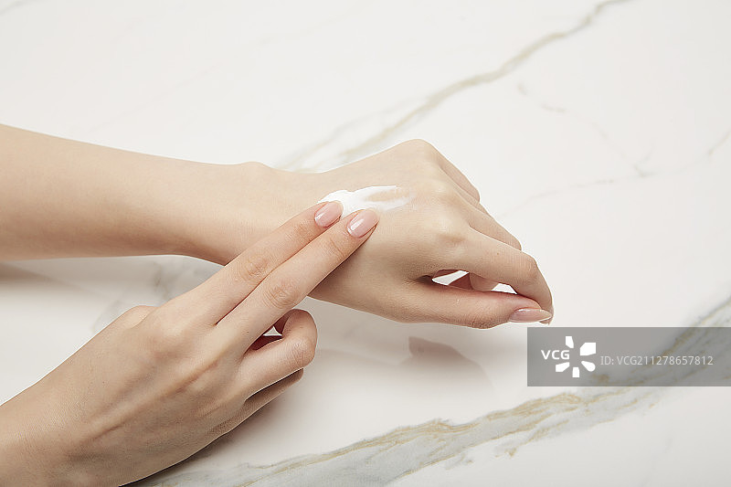 女子在手上涂抹护手霜摄影图片素材