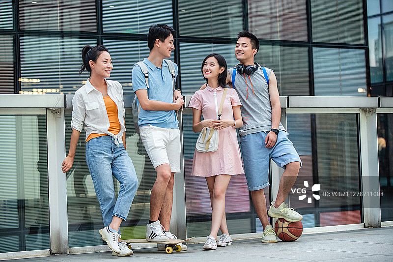 户外快乐的大学生倚栏而站图片素材