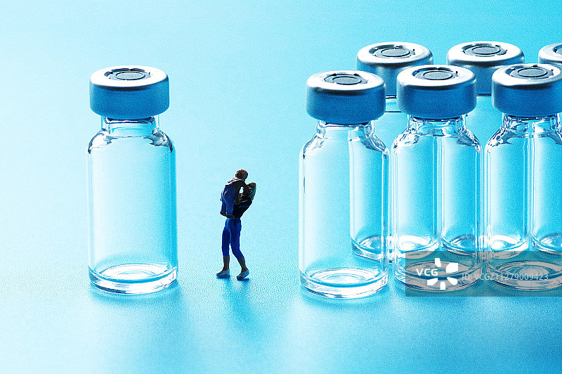 微缩摄影蓝色调注射器玻璃药瓶与母子人偶图片素材