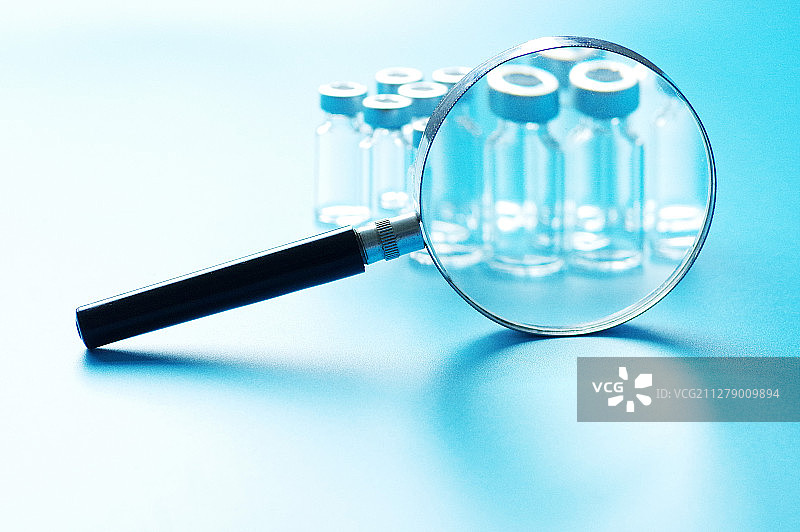 放大镜下的排列的玻璃药瓶图片素材