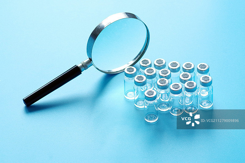 放大镜下的排列的玻璃药瓶图片素材