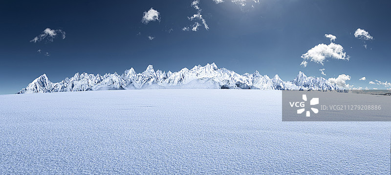 四川西部白昼蓝天下的贡嘎雪山及雪地背景图片素材