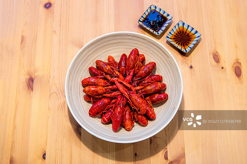 木桌上的一碗小龙虾与酱料正上方视角图片素材