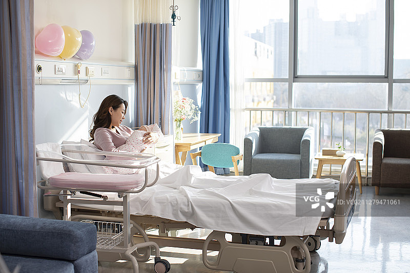 年轻的母亲在病房抱着刚出生的婴儿图片素材