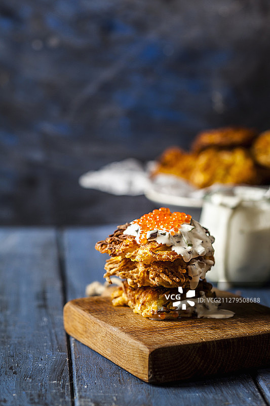土豆饼配炸韭葱、酸奶油和红鳟鱼子酱图片素材
