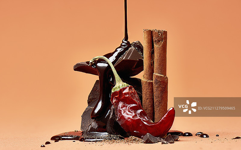 干辣椒、肉桂棒、肉桂粉和巧克力块与巧克力酱图片素材