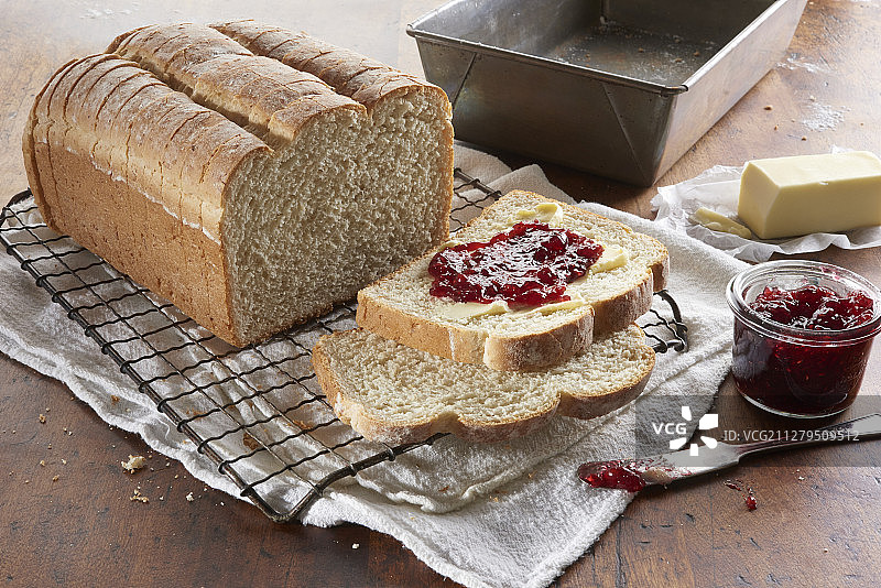 新鲜烘焙的面包切片，上面涂有黄油和浆果酱图片素材