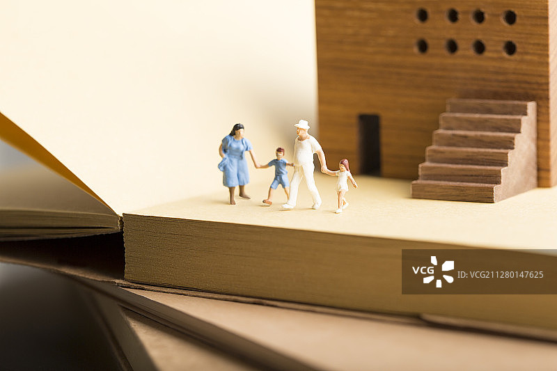 创意保险一家四口小玩偶、房子和书籍静物图片素材