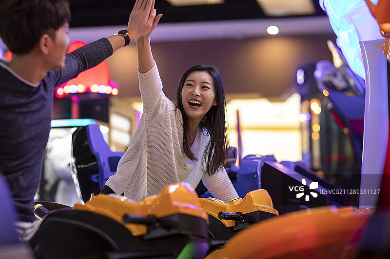 快乐的年轻情侣玩街机游戏图片素材