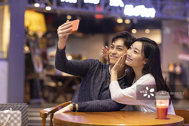 快乐的年轻情侣在商场自拍图片素材