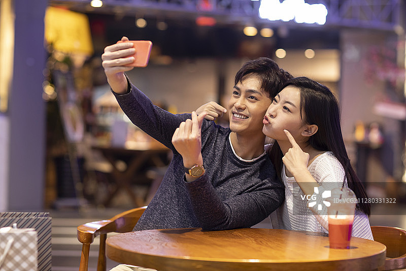 快乐的年轻情侣在商场自拍图片素材