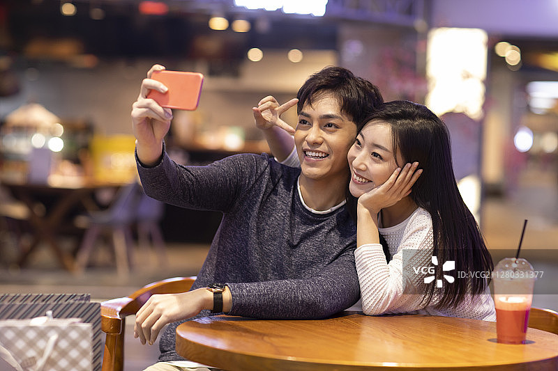 快乐的年轻情侣在商场自拍图片素材