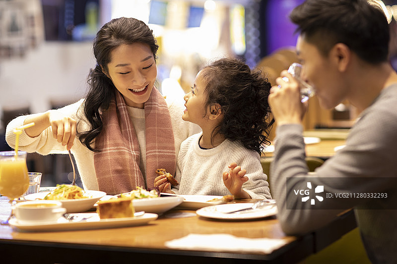 快乐的年轻家庭在餐厅就餐图片素材