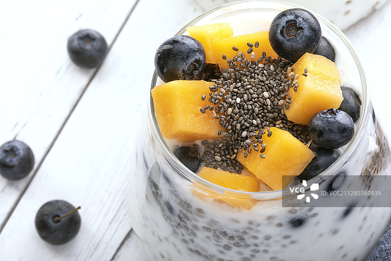 白色木桌上的一杯酸奶水果奶昔图片素材