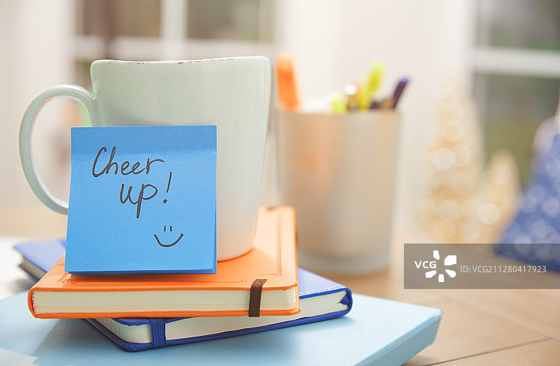 桌子上带有“加油”字样的便签纸和杯子、笔记本图片素材