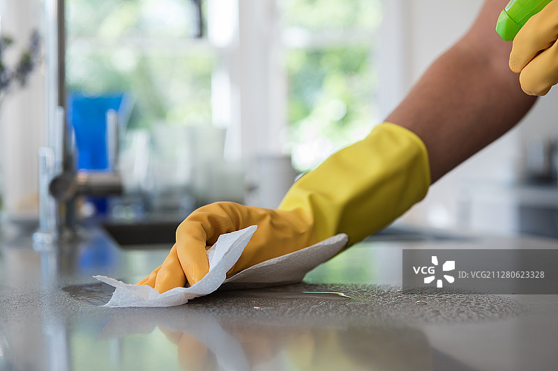 女子用喷雾和抹布清洁厨房台面图片素材