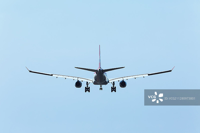 超低空飞行放出起落架准备降落的民航客机图片素材