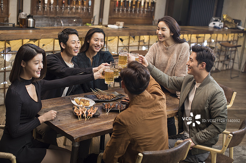 快乐的朋友们在酒吧干杯聊天图片素材