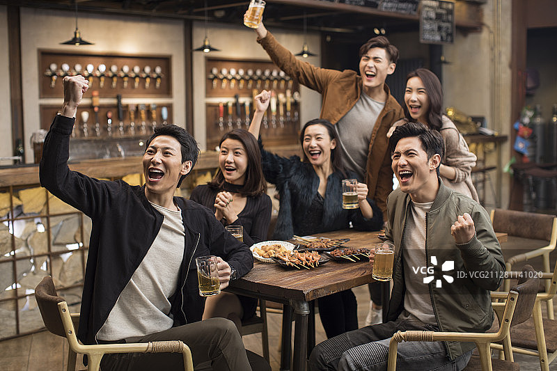 快乐的朋友们在酒吧欢呼图片素材