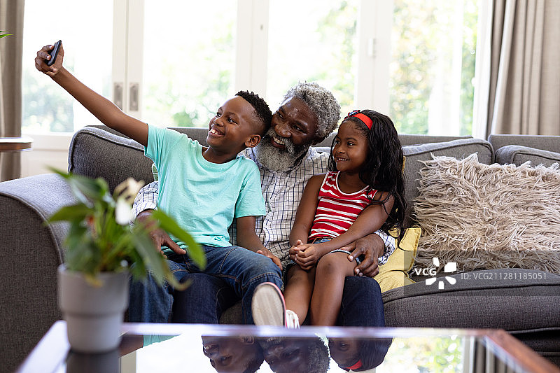 年长的非洲裔美国男人和他的孙子孙女们在家图片素材