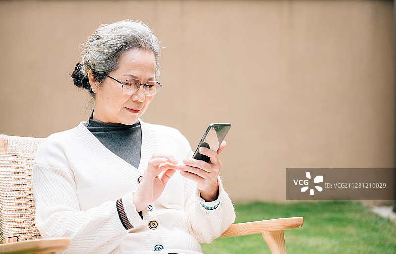 亚洲老年女性使用智能手机图片素材
