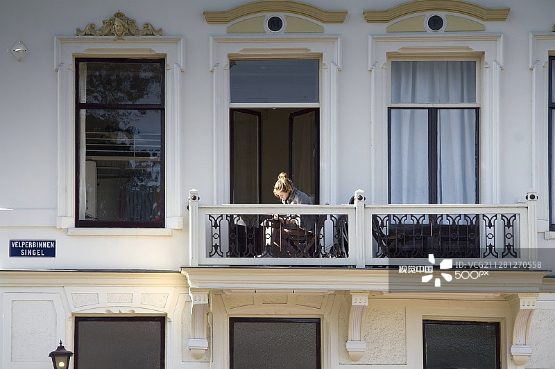 在荷兰阿纳姆 Velperbinnensingel 大厦阳台上的女孩图片素材