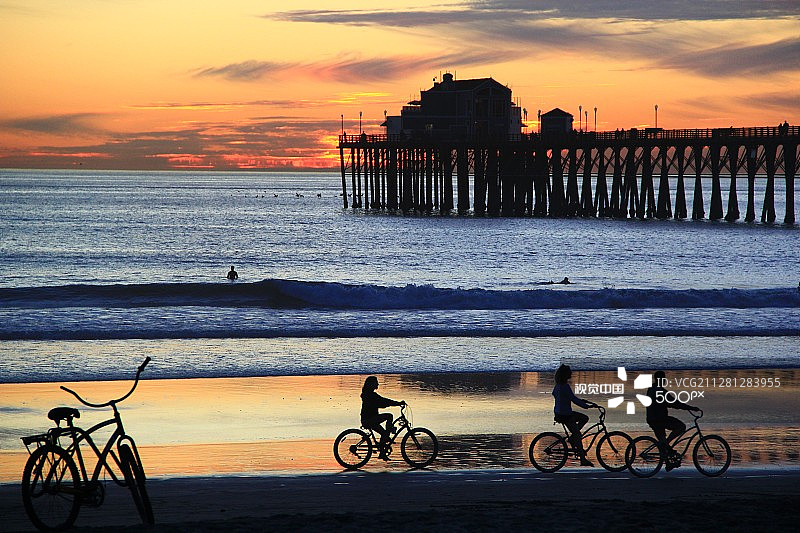日落时分在码头海滨骑自行车图片素材