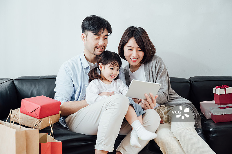 爸爸妈妈和女儿在家使用平板电脑图片素材