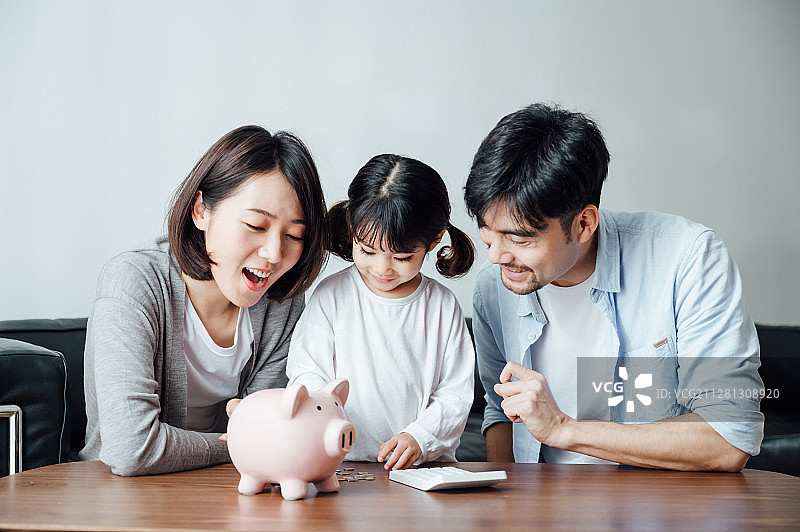 爸爸妈妈和女儿在家数硬币图片素材