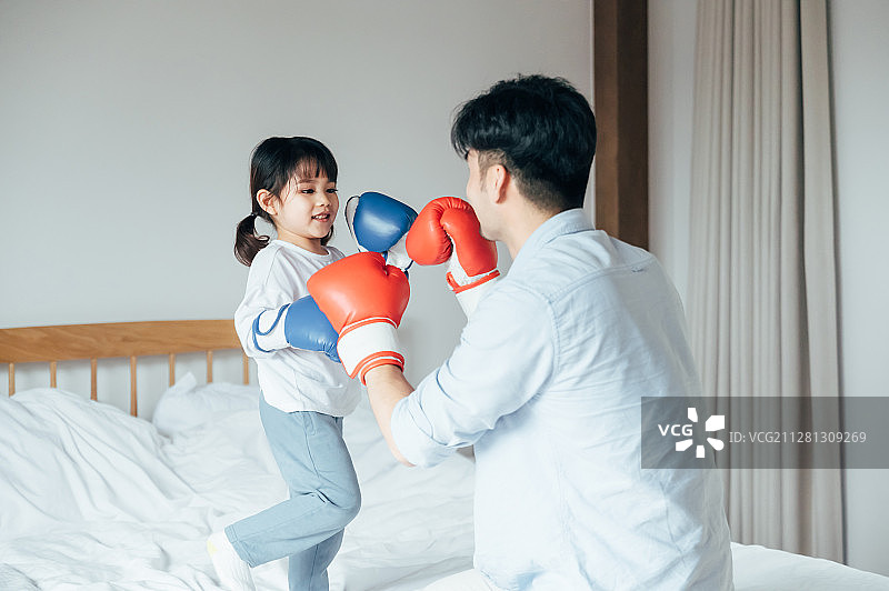 爸爸和女儿在床上打拳击图片素材