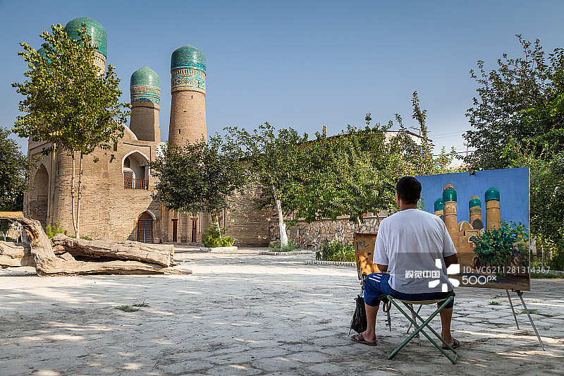 在乌兹别克斯坦布哈拉绘画历史建筑的男人图片素材