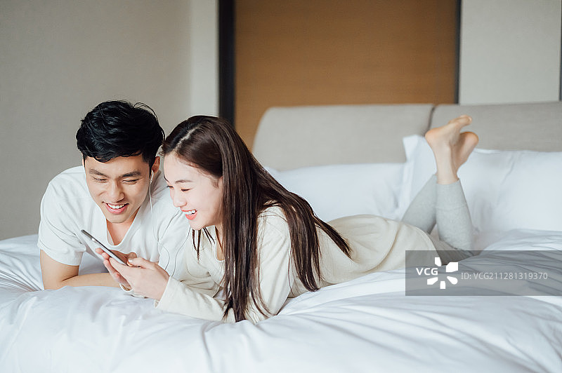 亚洲年轻情侣在家一起听歌图片素材