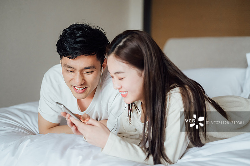 亚洲年轻情侣在家一起听歌图片素材