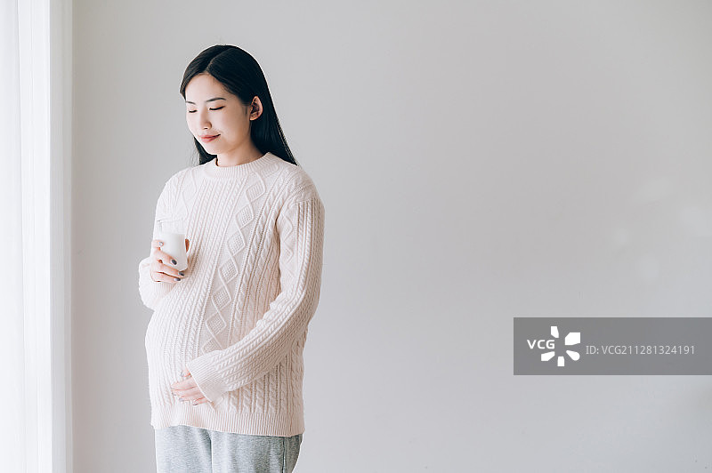 亚洲年轻孕妇喝牛奶图片素材