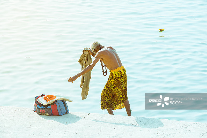 在印度瓦拉纳西，一位老人在恒河中沐浴图片素材