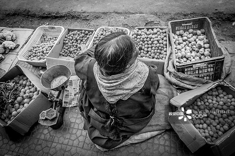 女子在人行道上卖杏图片素材