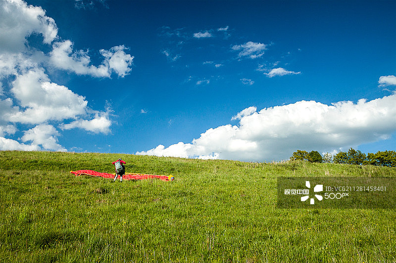 绿色草地上的红色滑翔伞图片素材